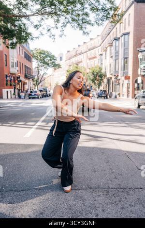 Junge Frau tanzt frei auf der städtischen Straße Stockfoto
