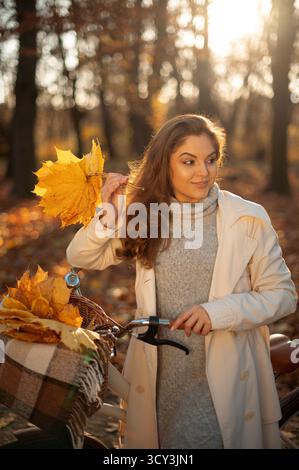 Nette Smiley Frau hält Herbstblätter in der Natur Stockfoto