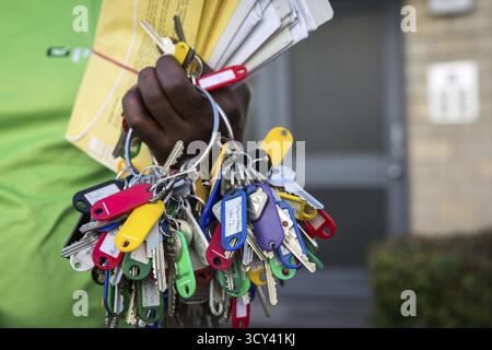 DEU Deutschland Berlin Ein Mitarbeiter der PIN AG hält beim Verteilen von Briefen einen großen Haufen Schlüssel in der Hand Stockfoto
