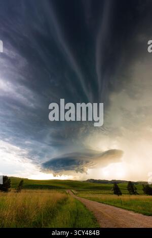 Moody Dark Sturmwolken erheben sich über einer staubigen Straße und vermischen dramatischen Himmel, ländliche Isolation, atmosphärische Spannungen, näheres Wetter, und die rohe Leistung Stockfoto