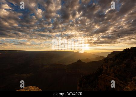 Wunderschöner Sonnenaufgang mit farbenfroher Wolkenbewegung über den Grand Canyon, der dramatischen Himmel, Sandsteinklippen und die atemberaubende landschaftliche Schönheit enthüllt Stockfoto