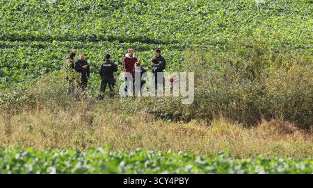 Klein Upahl, Deutschland. Oktober 2025. Polizeibeamte stehen neben dem Ort, an dem der achtjährige Fabian aus Güstrow tot in einem kleinen Teich bei Klein Upahl (rechts) aufgefunden wurde. Nach vorläufigen Autopsieergebnissen war der Grundschüler Opfer eines Gewaltverbrechens. Quelle: Bernd Wüstneck/dpa/Alamy Live News Stockfoto