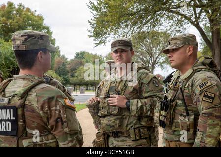 Der Stab der US-Armee, Sgt. Noah Boggs, links, und der SPC. John Grant, Mitte, mit dem 4. Bataillon, 118. Infanterieregiment, South Carolina National Guard, sprechen mit einem Soldaten der Georgia Army National Guard, nachdem er eine Patrouillenschicht in Washington, D.C., am 13. Oktober 2025 abgeschlossen hatte. Die Soldaten sind Teil der sicheren und schönen Mission von D.C., die das Engagement des Kriegsministeriums für Zusammenarbeit, Bereitschaft und öffentliche Sicherheit demonstriert. (Foto der Nationalgarde der US-Armee von Sgt. Jalen Miller) Stockfoto