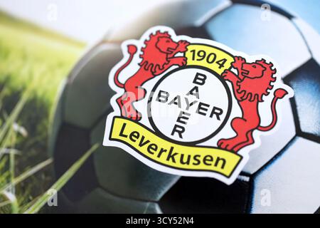 KIEW, UKRAINE - 23. FEBRUAR 2025 Bayer 04 Leverkusen Fußballklub-Abzeichen liegt auf einem Fußball-Hintergrund-Banner Stockfoto