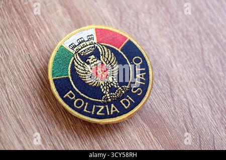 KIEW, UKRAINE - 6. SEPTEMBER 2025 Flicken der italienischen Staatspolizei auf brauner hölzerner Tischoberfläche Nahaufnahme Stockfoto