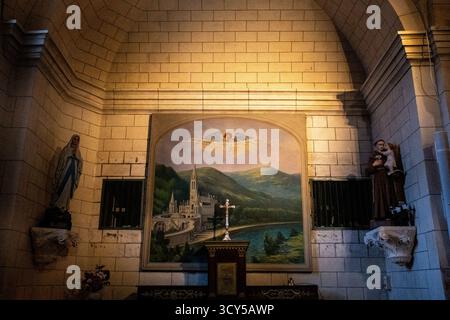 Blick auf das Innere von Eglise Saint Joseph mit einer Statue von Notre Dame de Lourdes und einem Wandgemälde in La Trinite sur Mer in Morbihan in der Bretagne Stockfoto