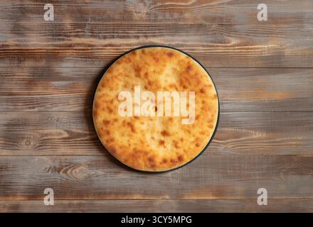 Traditioneller ossetischer Kuchen auf hölzernem Hintergrund. Blick von oben. Stockfoto