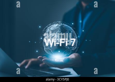 Person, die ein globales WLAN 7-Konnektivitätskonzept vorstellt. Zeigt einen holografischen Globus mit dem Wi-Fi 7-Technologiesymbol, das die nächste darstellt Stockfoto