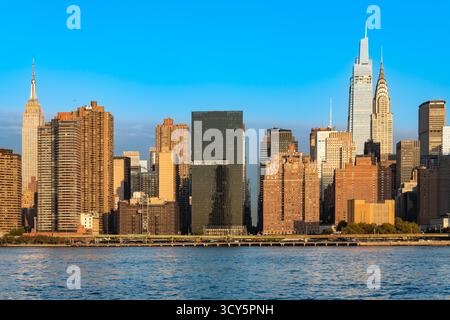 Ein wunderschöner Blick auf die Skyline von Midtown Manhattan mit dem Empire State und Chrysler Building bei Sonnenuntergang. Stockfoto