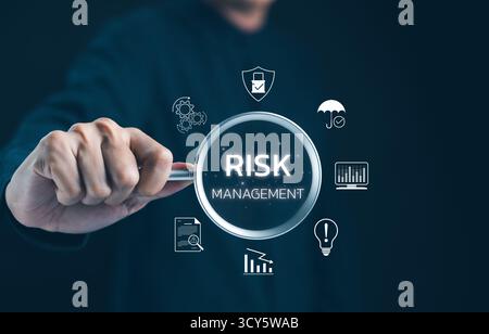 Professionelles Erforschen Von Risikomanagementkonzepten. Geschäftsmann konzentriert sich auf eine Lupe, die Symbole für Risikomanagement und Strategien hervorhebt Stockfoto