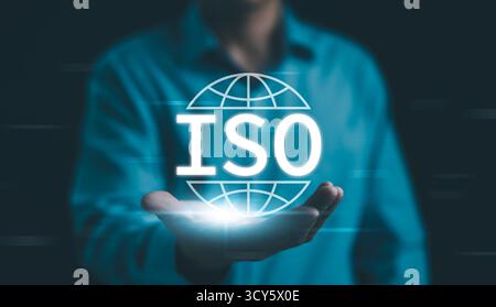 Qualitätssicherung nach ISO-Standards. Geschäftsmann trägt ein leuchtendes ISO-Symbol, das internationale Qualitätssicherung, -Sicherung und -Geschäft repräsentiert Stockfoto
