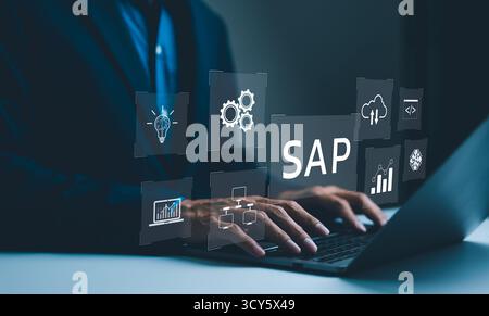 SAP, Business Process Automation and Management Software Konzept. Ein Geschäftsmann, der auf einem Laptop mit Symbolen für die Automatisierung von Geschäftsprozessen tippt Stockfoto