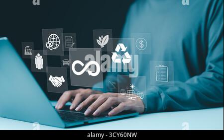 Kreislaufwirtschaft, Nachhaltigkeitskonzept. Person, die auf einem Laptop mit Symbolen für Kreislaufwirtschaft, Nachhaltigkeit, Recycling, umweltfreundliche Geschäftspraktiken tippt Stockfoto