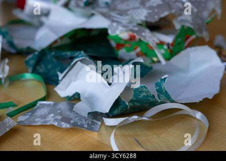 Zerrissene und leere Weihnachtsverpackung mit Klebeband auf dem Boden des Zimmers nach dem Auspacken der Geschenke. Eröffnung eines Weihnachtsgeschenks Stockfoto