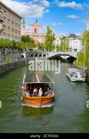 Touristenboote auf dem Fluss Ljubljanica in der Altstadt von Ljubljana, Slowenien Stockfoto