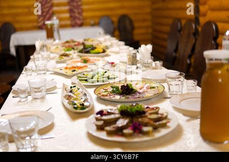 Lebhaftes mediterranes Festmahl mit einer Auswahl an Gerichten wie Wraps, Salaten, Grillfleisch und frischem Gemüse. Dieses farbenfrohe Aufstrich zeigt die reichen Aromen und die Vielfalt. Stockfoto