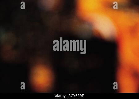 Sanfte orangefarbene Beleuchtung mit filmischer Unschärfe und körniger Staubüberlagerung für eine elegante, moderne Hintergrundstruktur für Design, Film und digitale Kunst Stockfoto