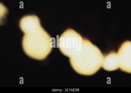 Sanfte gelbe Beleuchtung mit filmischer Unschärfe und körniger Staubüberlagerung für eine elegante, moderne Hintergrundstruktur für Design, Film und digitale Kunst Stockfoto