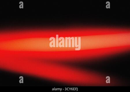 Sanfte rote Beleuchtung mit filmischer Unschärfe und körniger Staubüberlagerung für eine elegante, moderne Hintergrundstruktur für Design-, Film- und Digital Art-Profi Stockfoto