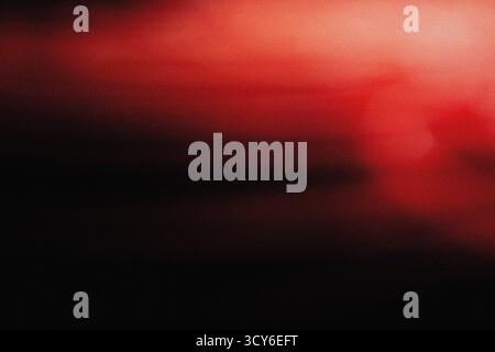 Sanfte rote Beleuchtung mit filmischer Unschärfe und körniger Staubüberlagerung für eine elegante, moderne Hintergrundstruktur für Design-, Film- und Digital Art-Profi Stockfoto