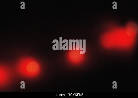 Sanfte rote Beleuchtung mit filmischer Unschärfe und körniger Staubüberlagerung für eine elegante, moderne Hintergrundstruktur für Design-, Film- und Digital Art-Profi Stockfoto