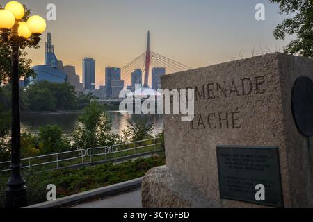 Promenade Taché Schild und Esplanade Riel Fußgängerbrücke über den Red River in der Innenstadt von Winnipeg, Manitoba, Kanada Stockfoto