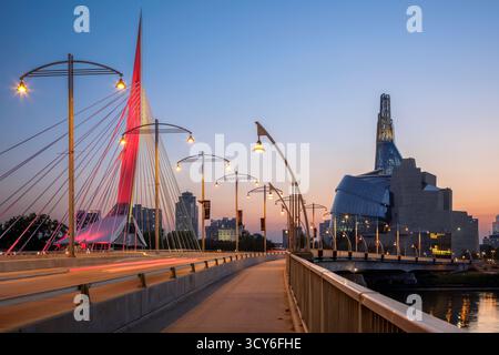 Die Fußgängerbrücke Esplanade Riel überquert den Red River bei Sonnenuntergang in der Innenstadt von Winnipeg, Manitoba, Kanada Stockfoto