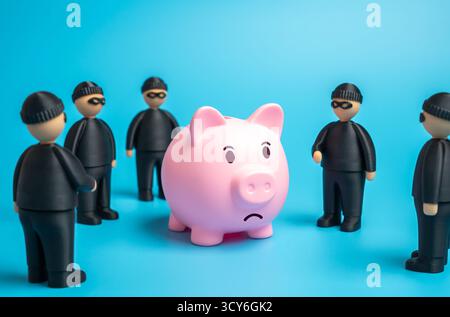 Räuber wollen Ersparnisse stehlen. Einsparungen sind gefährdet. Symbol für finanzielle Bedrohung, Betrug und Datendiebstahl. Banken, Versicherungen und Cybersicherheit Stockfoto