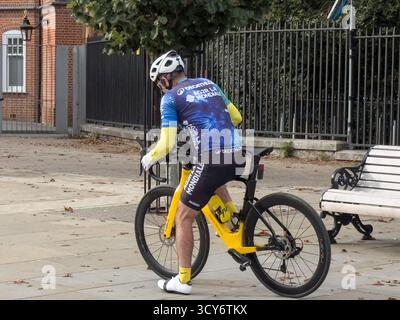 Ein Radfahrer in voller professioneller Radausrüstung bereitet sich auf ein Training im Greenwich Park in London vor – ein beliebter Ort für Outdoor-Sportarten in Großbritannien Stockfoto