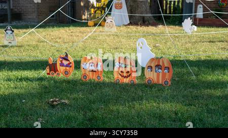 Ein fröhlicher Vorgarten ist voller niedlicher Halloween-Dekorationen, mit einer kleinen Kürbisbahn, die in diesem verspielten und festlichen Herbst-Sc den Weg ebnet Stockfoto