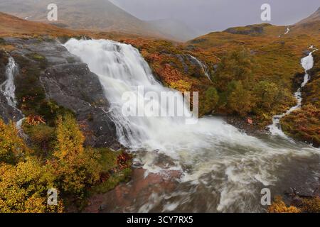 Der weiße Wasserfall stürzt den großen Fluss Allt Lairig Eilde hinunter, während er an den Falls of Coe, Pass of Glencoe, gerade besi in den Fluss Coe fällt Stockfoto