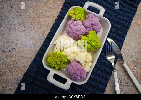 Verschiedene Wintergemüse in Einer weißen Auflaufform: Weiße und violette Blumenkohlröschen (Brassica oleracea Var. Botrytis) Und Die Grünen, Spiralen- Stockfoto