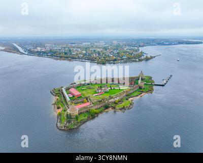 Breiter Panoramablick auf die Insel der Festung Oreshek im Zentrum, mit dem Wasser und der fernen Stadt im Hintergrund Stockfoto