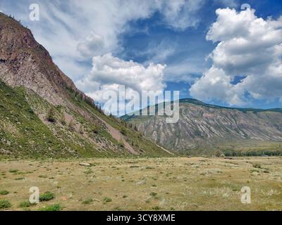 Berg mit Schwemmfächer. Zerklüftete Berglandschaft mit steilen Hängen, die mit verstreutem Grün bedeckt sind. Altai Berglandschaft natürliche Ba Stockfoto