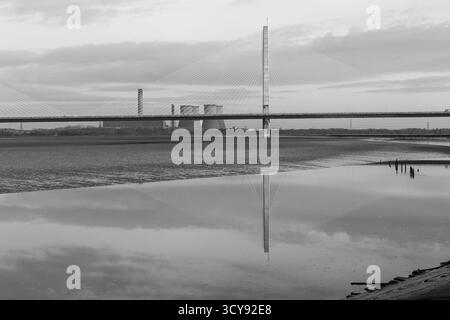 Monochromes Bild der Mersey Gateway Bridge, die den Mersey überspannt, mit den Kühltürmen des Fiddler’s Ferry Power Station im Hintergrund Stockfoto