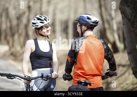 Zwei Radfahrer in Helmen am Nachmittag im Park Stockfoto