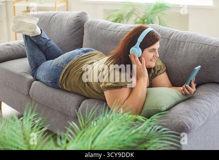 Glückliche Frau, Die Sich Online Mit Musik Zu Hause Entspannt Stockfoto