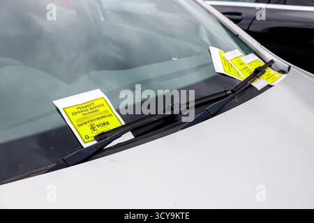 Geparktes Fahrzeug mit Benachrichtigung über Strafgebühren – „Benachrichtigung über Parkverstoß“ Stockfoto