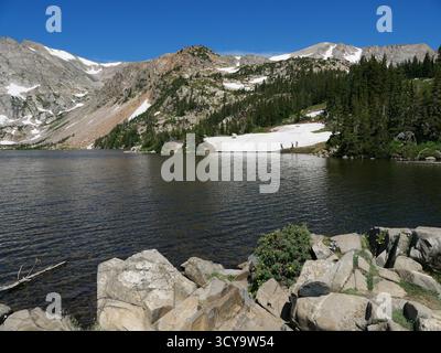 Malerischer Blick auf Lake Isabelle mit Alpine Peaks und Snowfields, Indian Peaks Wilderness, Colorado Stockfoto