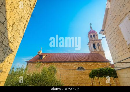 Foto einer alten Steinkirche in Sutivan mit traditioneller dalmatinischer Architektur, Glockenturm, Details zum kulturellen Erbe und mediterranem Charme Stockfoto