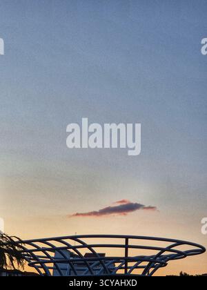 Sonnenuntergang am Himmel. Ungewöhnliche Wolke über moderner Architektur Stockfoto