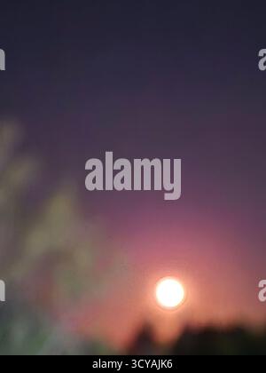 Der Himmel ist in tiefen Violett- und Rosa-Tönen gemalt. Die Magie der Dämmerung. Der rosafarbene Mond. Stockfoto