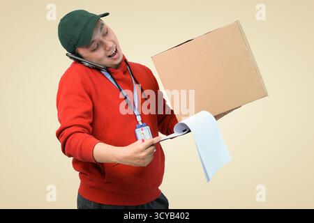 Ein Mitarbeiter mit rotem Hoodie-Balkendiagramm trägt beim Telefonieren eine glückliche Lieferung Stockfoto