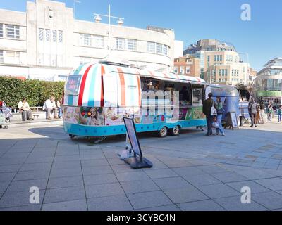 Street Food-Anbieter arbeiten mit umgebauten Airstream Caravans im Stadtzentrum von Brighton, England. Silberne Anhänger im Retro-Stil, in denen Speisen serviert werden Stockfoto