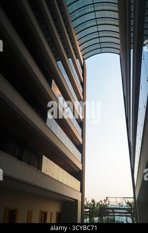 Modernes architektonisches Design mit schlanken Linien und großen Glasfenstern in einem urbanen Ambiente mit klarem Himmel. Stockfoto