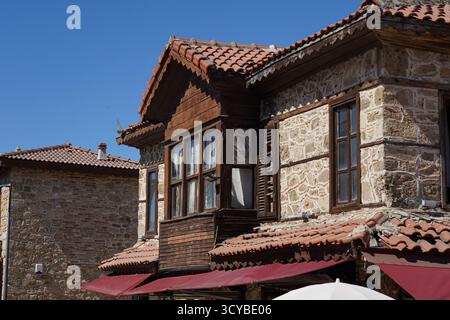 Side, Türkei - 17. September 2025: Charmantes architektonisches Detail eines traditionellen Steinhauses mit Holzelementen und roten Ziegeldächern unter einem Stockfoto