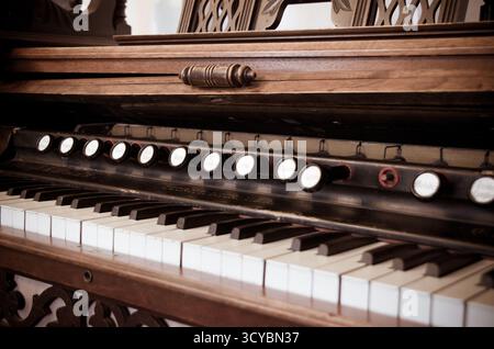 Nahaufnahme alter kaputter, staubiger Klaviertasten. Musik, die vom alten Ruinen des Klaviers gespielt wird. Hamel des Fadenöffnungsmechanismus Stockfoto