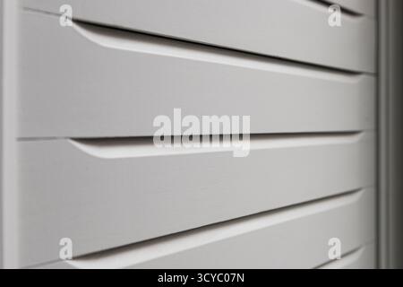 Nahaufnahme der Leisten einer weißen Holztür von einer Seite aus gesehen. Stockfoto