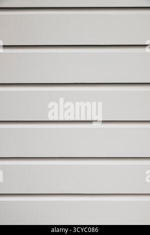Nahaufnahme der Lamellen einer weißen Holztür, von vorne gesehen, so dass sie parallel sind. Stockfoto