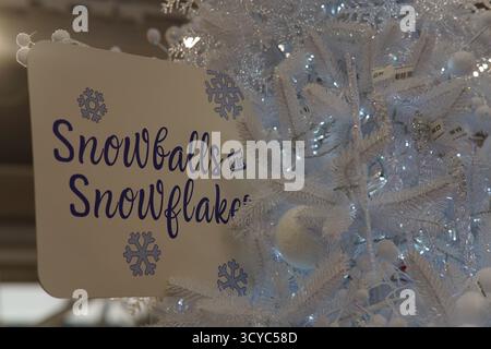 Weihnachtsschild „Schneebälle und Schneeflocken“ mit frostigen weißen Verzierungen im Haskins Garden Centre. Stockfoto